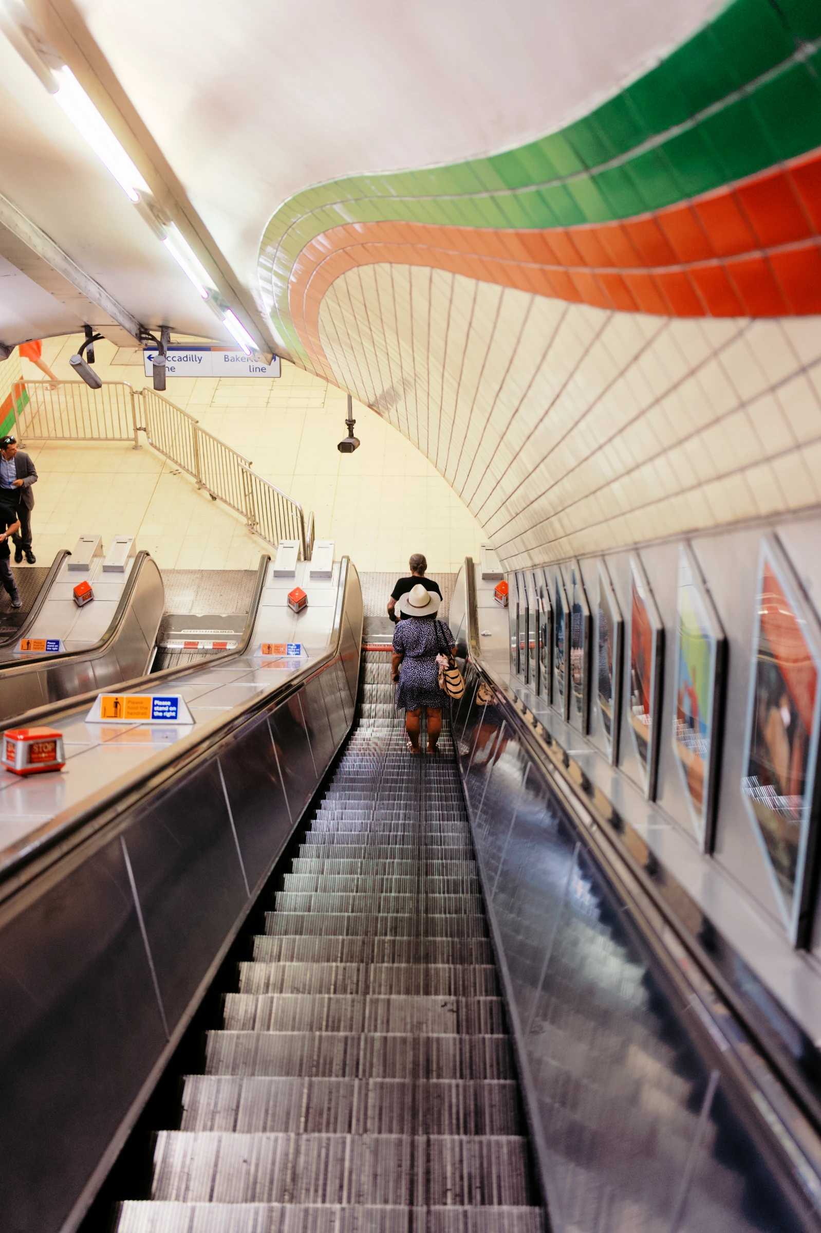 Curved Underground escalators, warm ceiling lights and red and green tiles, rendered with Chroma